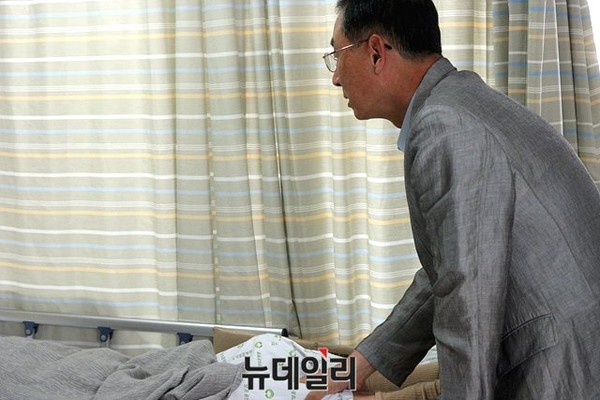▲ 아들 박홍건 예비역 대령이 뇌졸중으로 입원해 있는 아버지 박정인 장군의 다리를 주무르고 있다. 박정인 장군은 약한 모습을 보이기 싫다는 이유로 극구 사진 촬영을 거부했다. ⓒ박홍건