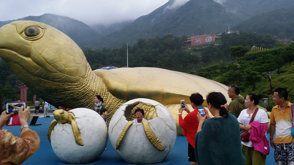▲ 중국 관광객들이 산청전통의약엑스포에서 대형 거북이를 배경을 사진 촬영을 하고 있다 산청군 ⓒ뉴데일리