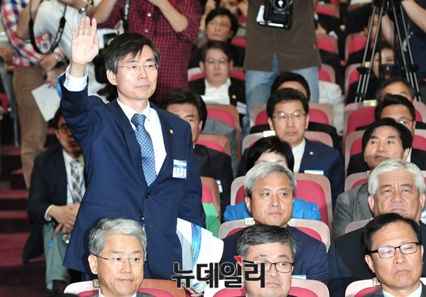 ▲ 새정치민주연합 조경태 의원이 16일 오후 소집된 중앙위원회의에서 손을 치켜들고 자리에서 일어나 회의의 의사 진행 절차에 대한 이의를 제기하고 있다. ⓒ뉴데일리 이종현 기자