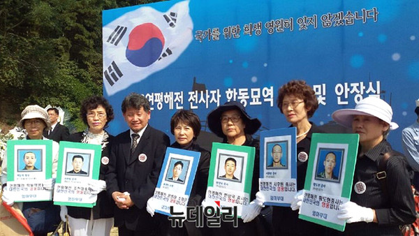 ▲ 21일 대현 현충원에 조성된 제2연평해전 전사자 합동묘역에서 엄마부대 회원들이 영화 연평해전 김학순 감독함께 6용사 영정을 들고 추모하고 있다 .ⓒ엄마부대