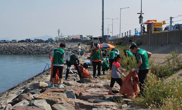 ▲ 삼천리 임직원 30여명과 시흥시 시민봉사자 30여명 등 60여명이 깨끗한 시화방조제를 만들기 위해 구슬땀을 흘리며 청소에 매진하고 있다. ⓒ삼천리