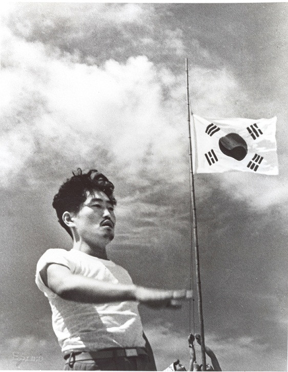 ▲ 6.25전쟁 중에 태극기 앞에선 음악가 윤용하,