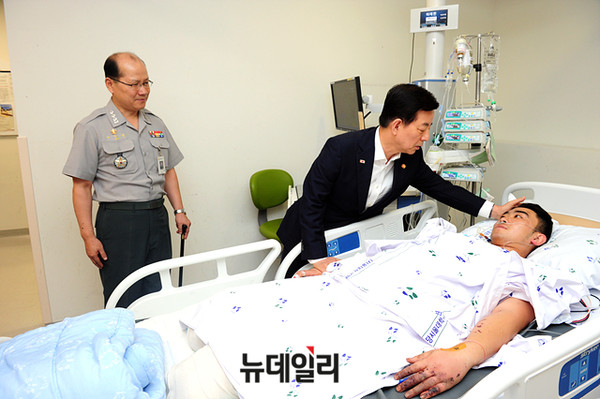 ▲ 이종명 대령(왼쪽)과 한민구 국방부 장관(가운데)가 지난달 7일, DMZ 수색작전 중 부상당한 하재헌 하사를 위문한 모습. ⓒ국방부