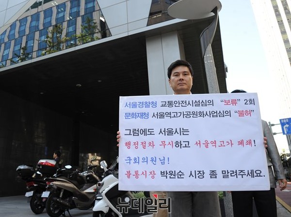 ▲ 지상욱 새누리당 서울 중구당협위원장이 지난달 17일, 서울시청 신청사 앞에서 서울역 고가 공원화 사업 반대를 주장하며 피켓시위를 벌이고 있는 모습. ⓒ뉴데일리 정재훈 기자