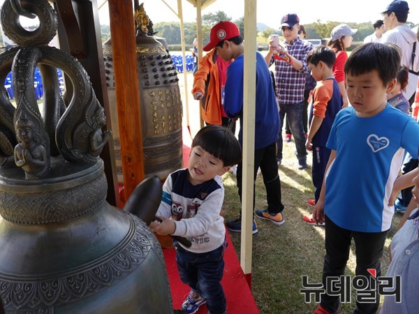 ▲ ‘ ‘2015 신라 소리축제 에밀레전’이 천년고도 경주에서 8~15일 까지 개최된다. 사진은 지난해 열린 에밀레 모형종 타종’에서 어린이가 타종을 하며 즐거워하고 있는 모습.ⓒ불교방송 제공