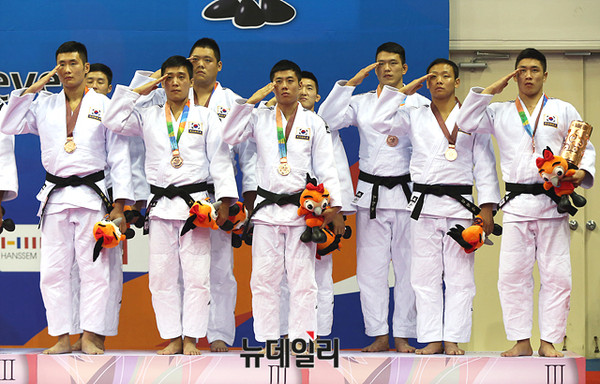 ▲ 3일 오후 경상북도 문경 국군체육부대에서 열린 2015 경북문경 세계군인체육대회 유도 남자 단체전에서 동메달을 따낸 대한민국 선수들이 시상대에 올라 국기에 대한 경례를 하고 있다. ⓒ2015 경북문경 세계군인체육대회 조직위