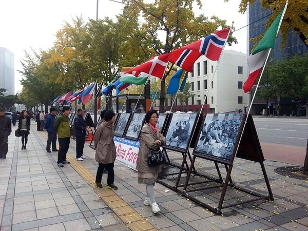 ▲ 프레스센터 앞에서 열린 '생명의 항해 6.25전쟁 사진전'을 시민들이 둘러보고 있다.  ⓒ 자료 제공 = 월드피스자유연합