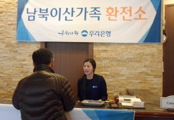 ▲ 19일 20차 남북이산가족 상봉행사를 위해 강원도 속초 한화리조트에 설치한 우리은행 임시환전소에서 직원이 고객에게 환전을 해주고 있다. ⓒ 우리은행