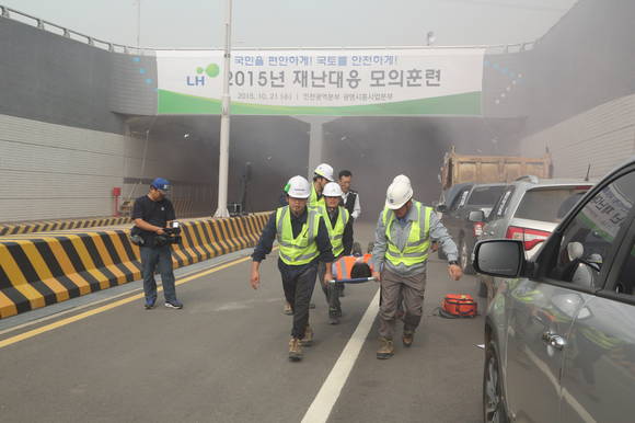 ▲ LH 직원들이 21일 LH 인천지역본부 관할 시흥장현지구에서 개최된 2015년 하반기 재난대응 모의훈련에 참석해 '지하차도 내 차량 연쇄추돌에 따른 긴급구조' 훈련을 하고 있다.ⓒLH