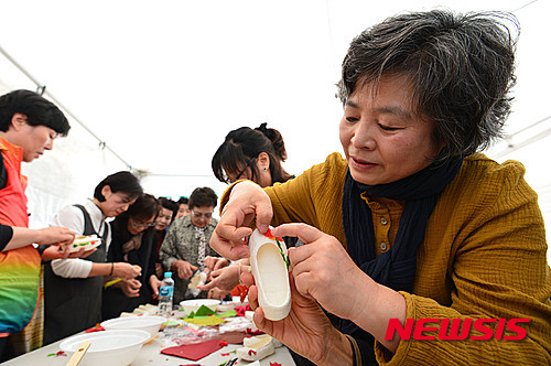 ▲ 22일 오후 서울 중구 서울광장에서 열린 '2015 서울 문화원 엑스포'에서 종로문화원 부스를 찾은 시민들이 닥종이 공예를 체험하고 있다.   ⓒ 뉴시스