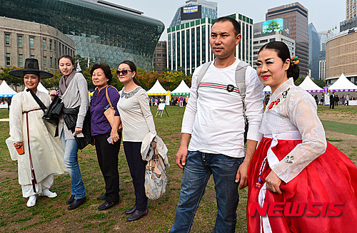 ▲ 22일 오후 서울 중구 서울광장에서 열린 '2015 서울 문화원 엑스포' 민속 전통놀이 체험마당에서 외국인 관광객들이 한복을 입은 시민들과 사진촬영을 하고 있다.    ⓒ 뉴시스