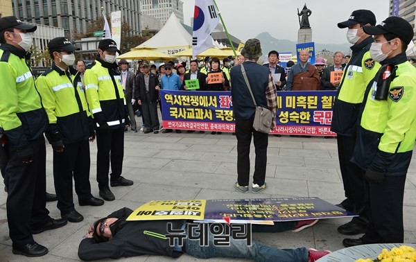 ▲ 세월호 농성천막촌에서 나온 한 남성이 광화문광장 이순신 장군 동상 앞에서 기자회견을 하는 애국단체를 비아냥거리며 소란을 피우고 있는 모습.ⓒ뉴데일리