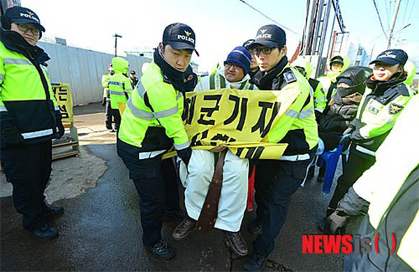 ▲ 2015년 1월 제주해군기지 공사장 앞에서 기지건설반대 미사를 불법으로 벌이다 경찰에 쫓겨나는 정의구현사제단 신부. ⓒ뉴시스. 무단전재 및 재배포 금지.