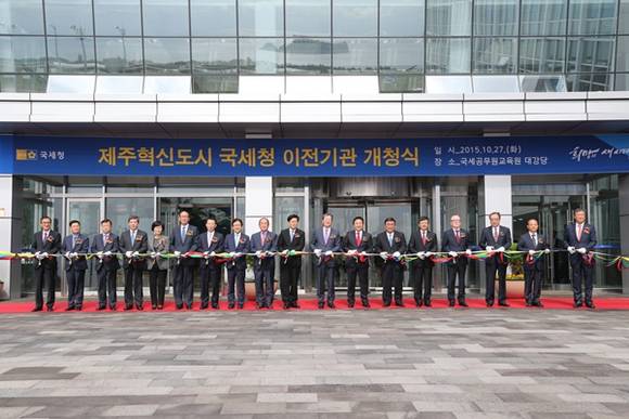 ▲ 27일 제주혁신도시에서 열린 국세청 산하 국세공무원교육원, 주류면허지원센터, 고객만족센터 등 3개 기관 개청식에서 임환수 국세청장(왼쪽 11번째) 등 주요 참석자들이 기념 테이프를 자르고 있다. ⓒ국세청