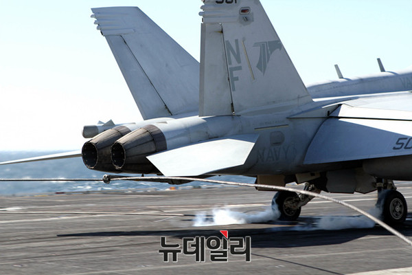 ▲ 28일 로널드 레이건호 비행갑판에서 착륙(착함)하는 F-18E 슈퍼호넷 전투기. 사진상 슈퍼호넷 후미 어레스팅 후크가 와이어가 걸리며 제동이 걸린다.ⓒ뉴데일리 순정우 기자