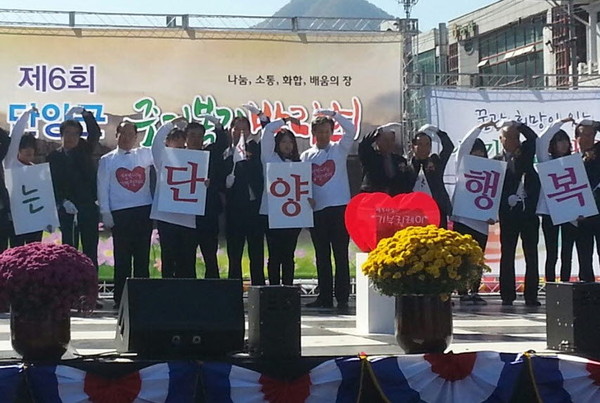 ▲ 단양군 주민복지박람회에서 류한우 군수와 관계자들이 이웃사랑 하트 모양을 그리고 있다. 사진제공=단양군