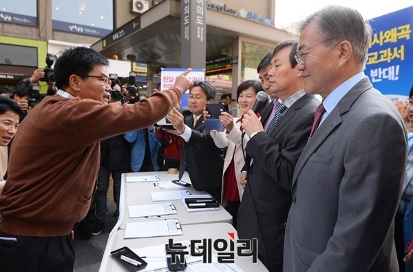 ▲ 새정치민주연합 문재인 대표를 비롯한 당 지도부가 지난달 13일 서울 여의도역 근처에서 역사교과서 국정화에 반대하는 서명운동을 전개하던 중 어버이연합 소속 회원으로부터 항의를 받고 있다.  ⓒ이종현 기자