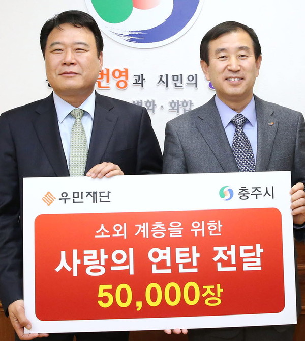 ▲ 장덕수 우민재단 이사장(왼쪽)이 조길형 충주시장에게 연탄 5만장을 기탁했다. 사진제공=충주시