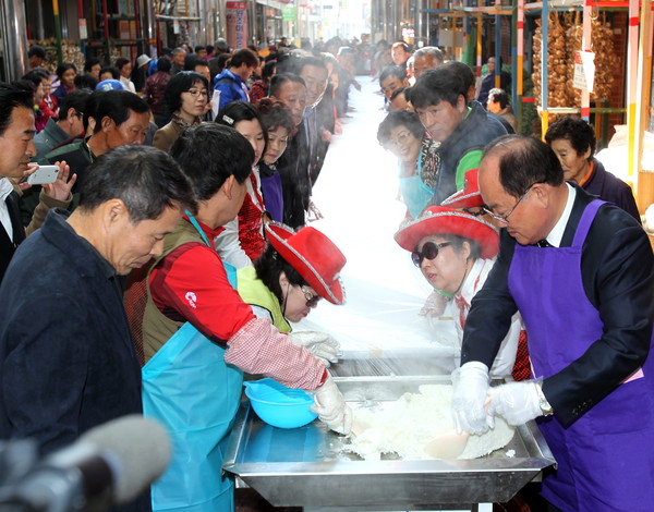 ▲ 류한우 단양군수(오른쪽)가 단양구경시장에서 주민들과 함께 가래떡을 만들고 있다. 사진제공=단양군