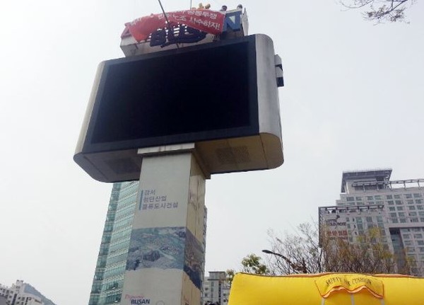 ▲ 부산시청 앞 11m 높이의 전광판 점거 시위ⓒ사진출처 부산일보