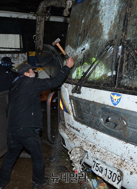 ▲ 4일 밤, '민중총궐기' 폭력시위에 가담한 한 남성이 경찰버스에 쇠망치를 휘두르고 있다. ⓒ 뉴데일리 정상윤 기자