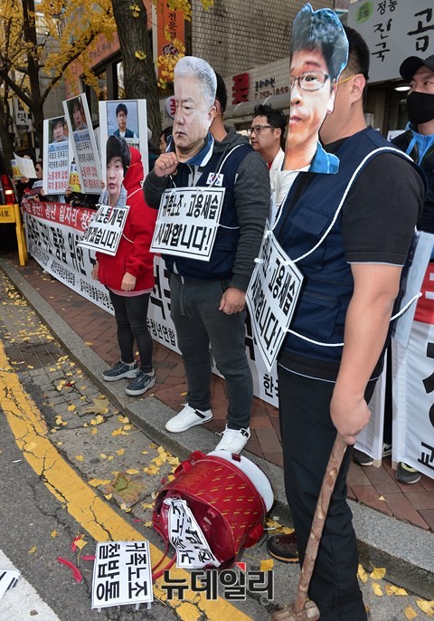 ▲ 청년·대학생들이 한상균 민노총 위원장과 김동만 한국노총 위원장, 김영주 국회 환경노동위 위원장 등의 얼굴 가면을 쓰고 민노총의 '철밥통'을 상징하는 전기밥솥을 대형헤머로 부수는 퍼포먼스를 벌였다. ⓒ뉴데일리 정상윤 기자