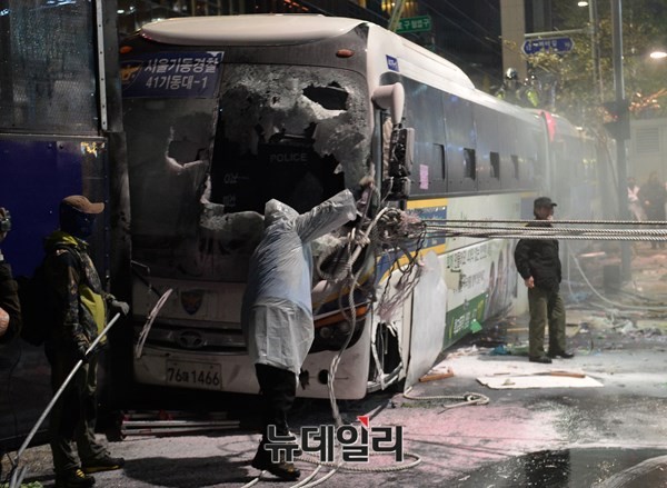 ▲ 시위대의 폭력시위로 파손된 경찰버스. 시위참가자들이 버스에 밧줄을 묶어 전복을 시도하고 있다. ⓒ 뉴데일리 정상윤 기자