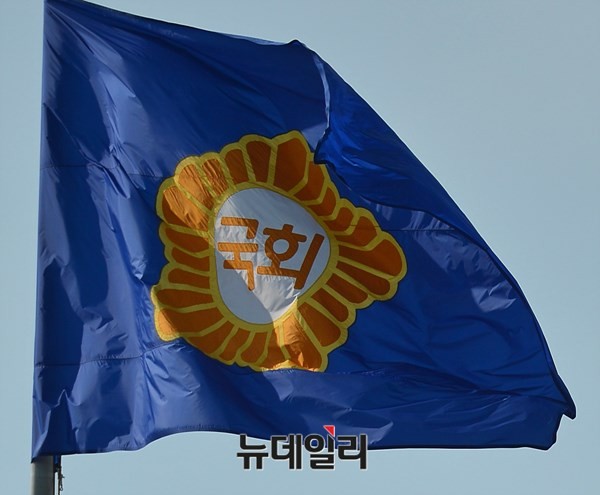 ▲ 선거구 협상 막판에 다시 의원 정수 증원 카드가 깜짝 등장할 수도 있다는 관측이어서 국민의 우려와 근심이 깊어지고 있다. 사진은 바람에 나부끼고 있는 국회 깃발. ⓒ뉴데일리 정상윤 기자