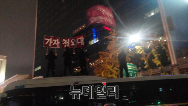 ▲ 지난 14일 '민중총궐기' 집회에 나타난 플랜카드. 차벽으로 세워진 경찰버스를 끌어내고 그 위에 올라서서 '가자 청와대'라고 쓰여진 팻말을 높이 들었다. ⓒ뉴데일리 임재섭 기자