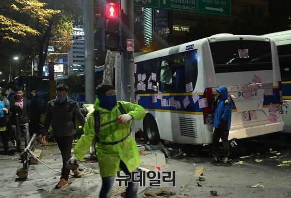 ▲ 지난 14일 광화문 불법시위에 참석한 시위대들이 마스크를 쓴 채 경찰을 향해 돌을 던지고 있다.ⓒ뉴데일리