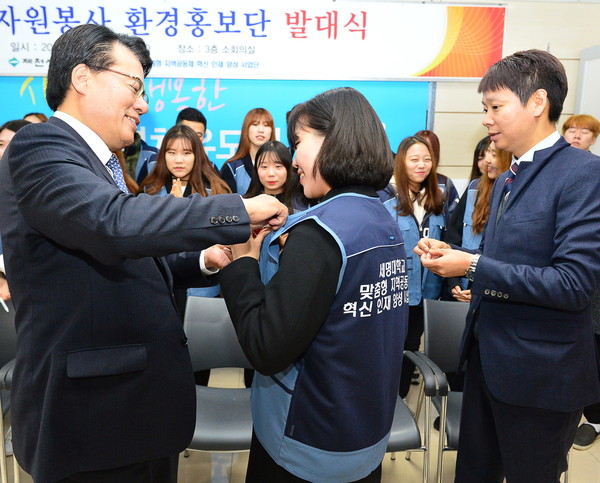 ▲ 이근규 제천시장(왼쪽)이 환경홍보단 학생에게 뺏지를 달아주고 있다.사진제공=제천시