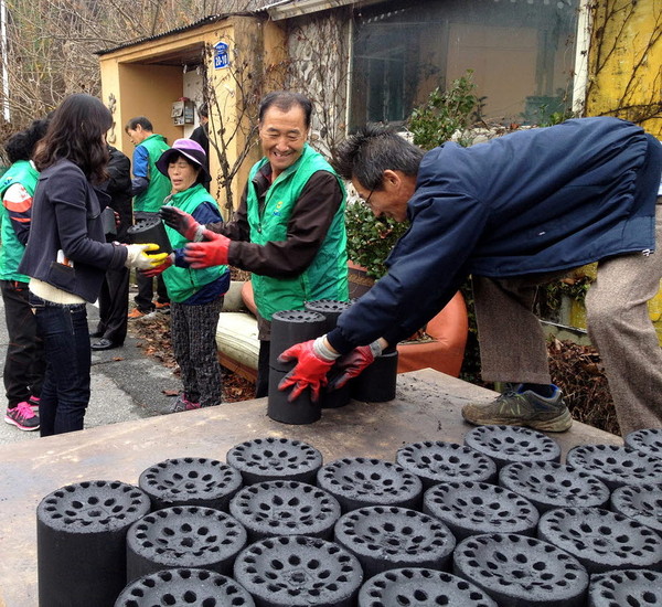 ▲ 동량면 새마을지도자협의회 회원들이 연탄을 나르고 있다.사진제공=충주시