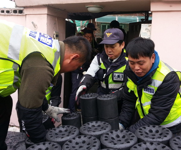 ▲ 충주시 문화자율방범대원들이 연탄을 나르고 있다.사진제공=충주시