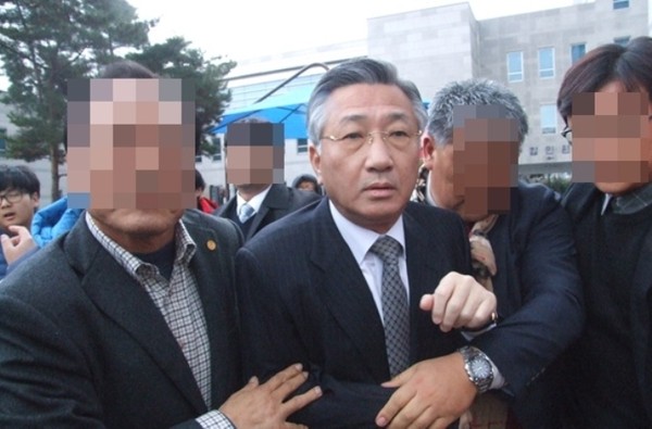 ▲ 이날 불구속 기소된 김윤배 청주대 전 총장이 법정을 나오는 과정에서 퇴진요구서를 전달하려는 청주대 총학생회 간부 등을 뿌리치며 황급히 몸을 피하고 있다ⓒ뉴데일리