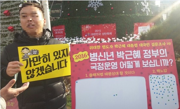 ▲ 대통령 비하 선전물을 들고 있는 집회 참가자. ⓒ 뉴데일리 이길호 기자