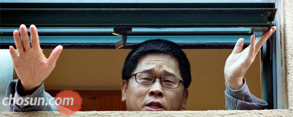 ▲ 1일 오후 서울 종로구 조계사 관음전 창문으로 모습을 드러낸 한상균 민노총 위원장. ⓒ 조선닷컴