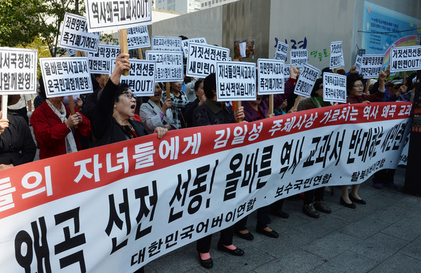 지난 10월 13일 서울 여의도역 입구에서 새정치민주연합이 국정 교과서 반대 대국민 서명운동을 펼치고 있는 동안 맞은편에서 애국단체 회원들이 국정교과서 추진 찬성 집회를 하고 있다.