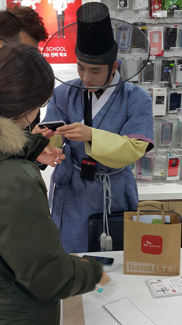 ▲ '꽃선비' 이웅비씨가 매장에서 한복을 입은채 고객에게 휴대폰 영업을 하고 있다. ⓒ뉴데일리