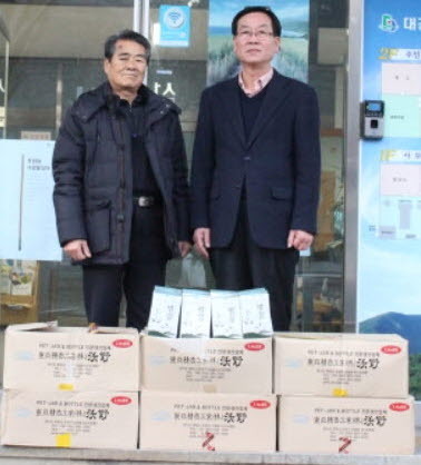 ▲ 도기춘 이장(왼쪽)이 대강면에 벌꿀을 전달하고 있다.사진제공=대강면사무소