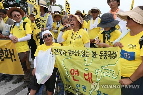 ▲ 지난 7월 '제주해군기지 반대운동 3,000일 행사'에 참석한 필리핀 여성의 모습. 그 앞의 현수막을 주의깊게 보자. ⓒ연합뉴스. 무단전재 및 재배포 금지.