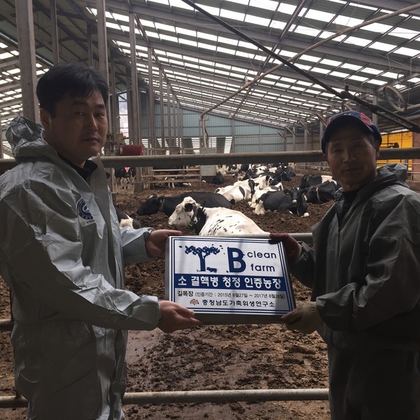 ▲ 사진은 가축위생연구소 허진회 방역팀장이 ‘길농장’ 정목환 씨에게 인증마크를 전달하고 있다.ⓒ뉴데일리