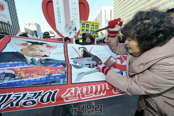 ▲ 권명호 나라사랑어머니연합 대표가 8일 광화문 광장에서 열린 기자회견 자리에서, 김정은의 사진이 인쇄된 현수막을 칼로 찢는 퍼포먼스를 벌이고 있다. ⓒ뉴데일리 정재훈 기자