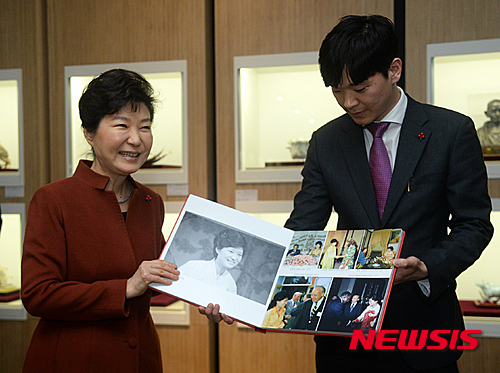 ▲ 박근혜 대통령이 14일 오후 세종시 대통령기록관 개관식에 참석, 기록관 직원들로부터 옛날 사진을 선물 받고 있다. ⓒ뉴시스