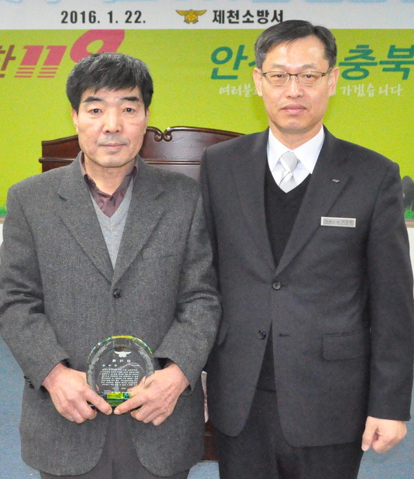 ▲ 최태섭씨(왼쪽)가 화재진압 유공시민 감사패를 받고 있다.ⓒ제천소방서