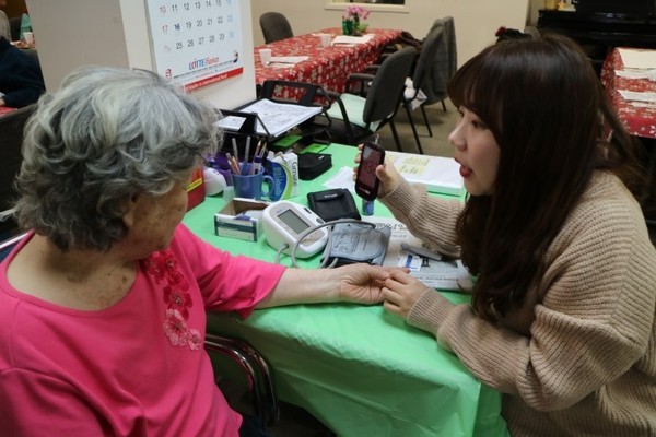 ▲ 노인요양기관을 방문한 대구대 한 학생이 할머니의 혈압을 체크해주며 얘기를 나누고 있다.ⓒ대구대 제공