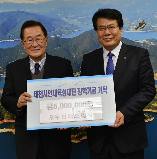 ▲ 김원희 ㈜우신에스엠씨 대표(왼쪽)가 이근규 시장에게 장학금을 전달하고 있다ⓒ제천시
