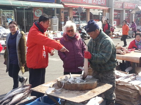 ▲ 김동주 예비후보가 전통시장에서 생선을 구입하고 있다. ⓒ김동주 보