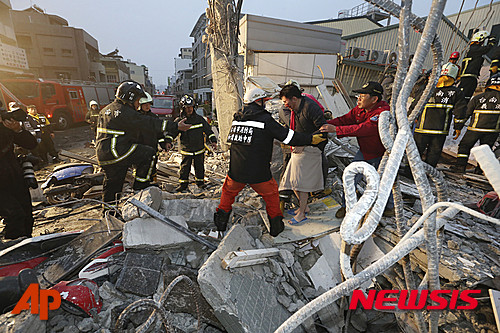 ▲ 대만 구조대원들이 남부 타이난(台南)에서 지진으로 무너진 견물에서 구조한 남성을 안내하고 있다.  ⓒ 뉴시스