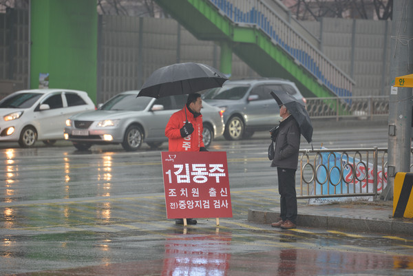 [포토] 김동주 예비후보가 비오는 날씨에도 시민에게 인사를 하고있다.ⓒ김동주