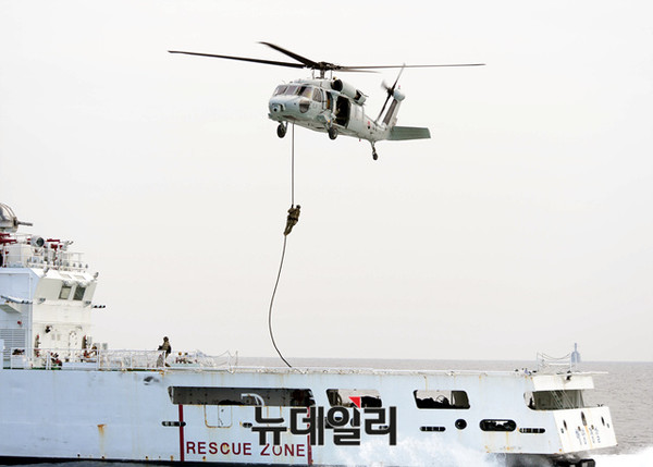 ▲ 특수전전단(UDT/SEAL) 대테러팀이 해군 UH-60 헬기에서 해경 제민12호(피랍 상선 모사) 함미 헬기갑판으로 공중 침투하고 있다.ⓒ해군